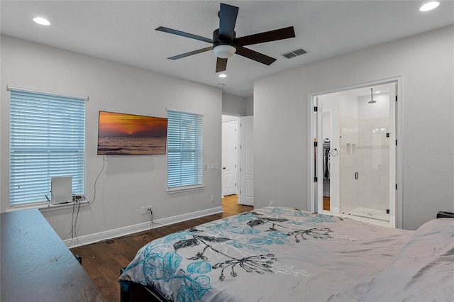 bedroom featuring connected bathroom, ceiling fan, dark wood-type flooring, and multiple windows