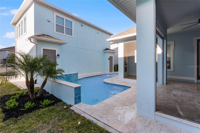 view of pool with ceiling fan and a patio