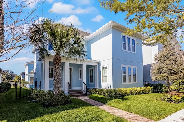 view of front of home with stucco siding, fence, a porch, and a front yard