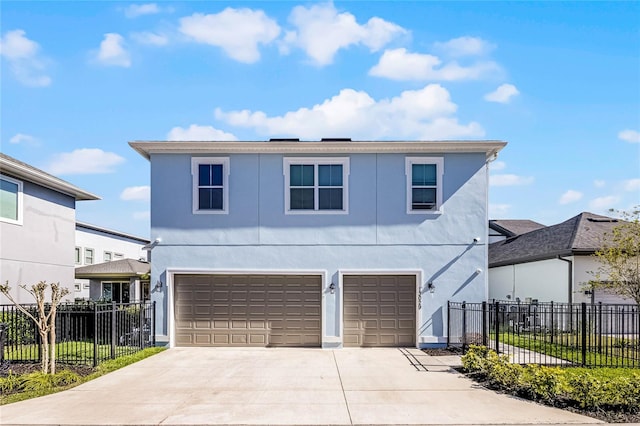 view of front facade featuring fence, driveway, an attached garage, and stucco siding