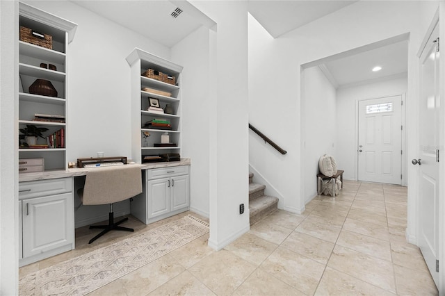 home office featuring crown molding and built in desk