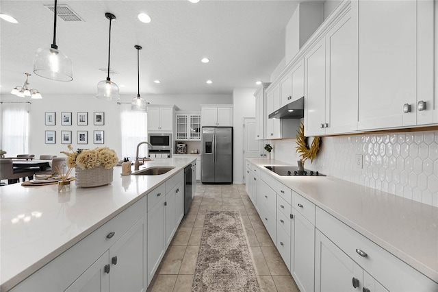 kitchen featuring sink, black appliances, pendant lighting, white cabinets, and light tile patterned flooring