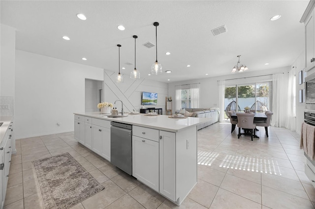 kitchen featuring dishwasher, sink, hanging light fixtures, a center island with sink, and white cabinets