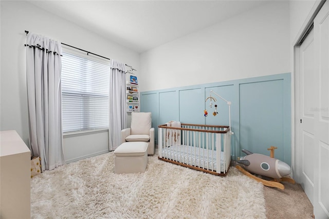 bedroom featuring carpet flooring and a crib