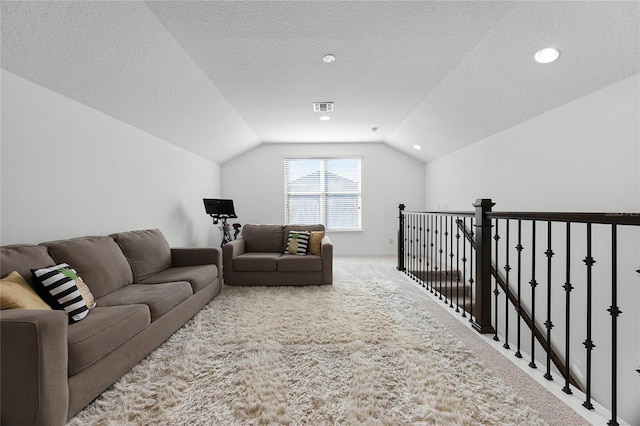 living room with a textured ceiling, carpet, and vaulted ceiling