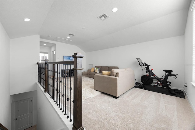 living room with a textured ceiling, light carpet, and lofted ceiling