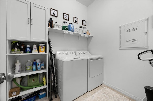 washroom featuring separate washer and dryer, electric panel, and cabinets