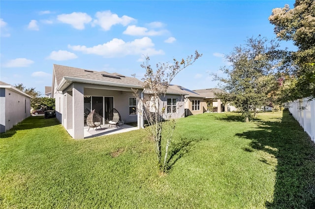 rear view of property with a lawn and a patio area