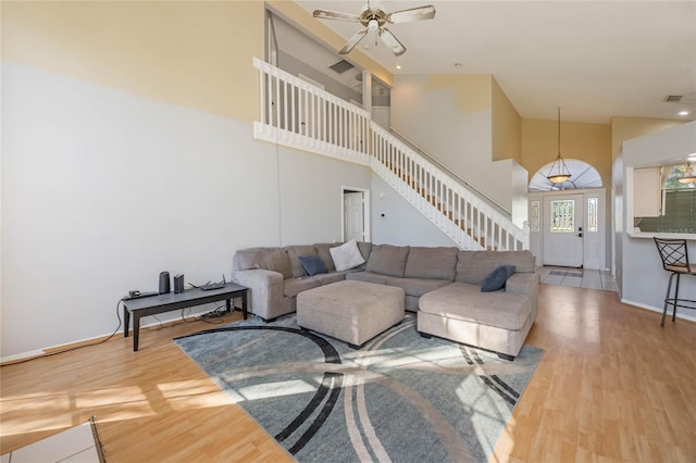 living room with ceiling fan, hardwood / wood-style floors, and high vaulted ceiling