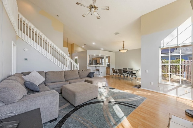 living room featuring ceiling fan, light hardwood / wood-style flooring, and high vaulted ceiling