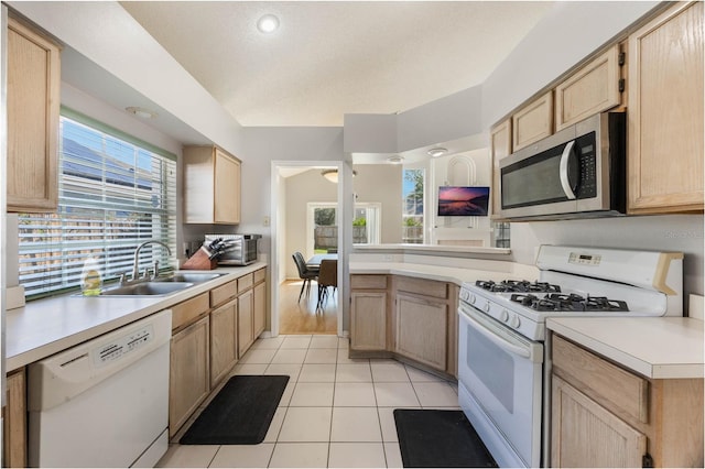 kitchen featuring light brown cabinetry, white appliances, a textured ceiling, sink, and light tile patterned floors