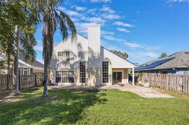 back of property with a patio area and a yard