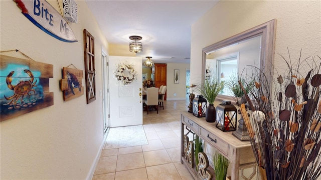 hallway with baseboards and light tile patterned floors