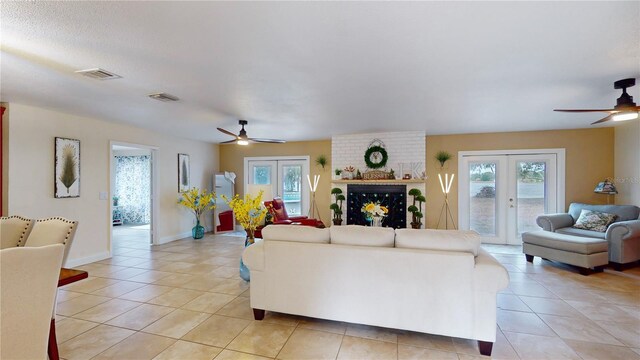 living area featuring light tile patterned floors, visible vents, and french doors