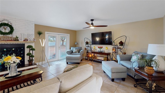 living room with french doors, a fireplace, light tile patterned flooring, ceiling fan, and baseboards