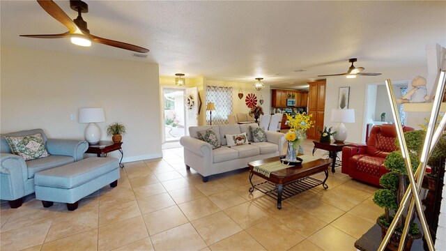 living area featuring light tile patterned floors, visible vents, and a ceiling fan