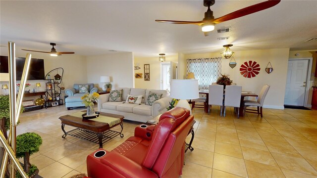 living room featuring a ceiling fan, visible vents, and light tile patterned floors