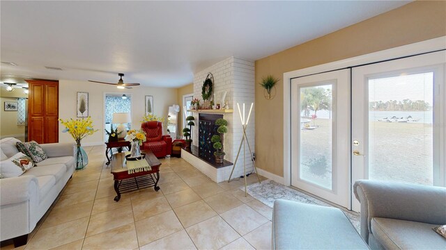 living room with light tile patterned floors, visible vents, ceiling fan, french doors, and a fireplace