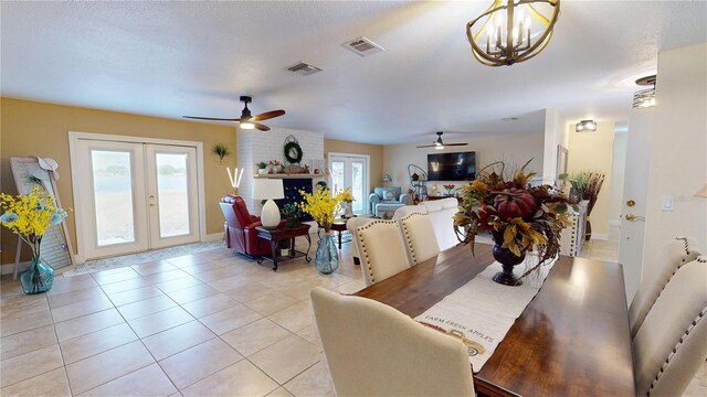 dining space featuring light tile patterned floors, french doors, a textured ceiling, and visible vents