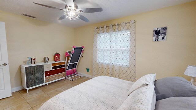 bedroom with visible vents, ceiling fan, baseboards, and light tile patterned floors