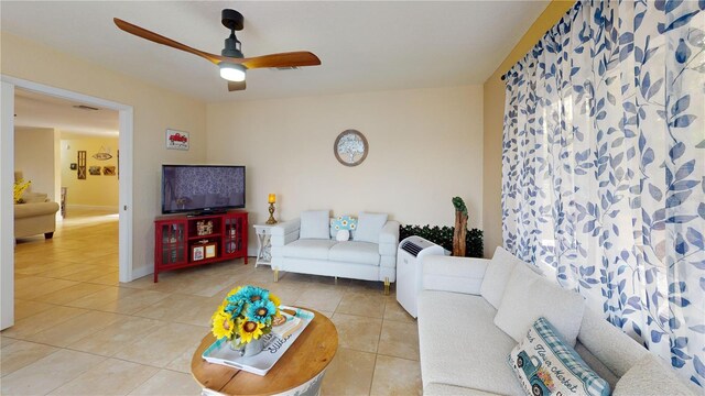 living area with visible vents, baseboards, a ceiling fan, and light tile patterned flooring