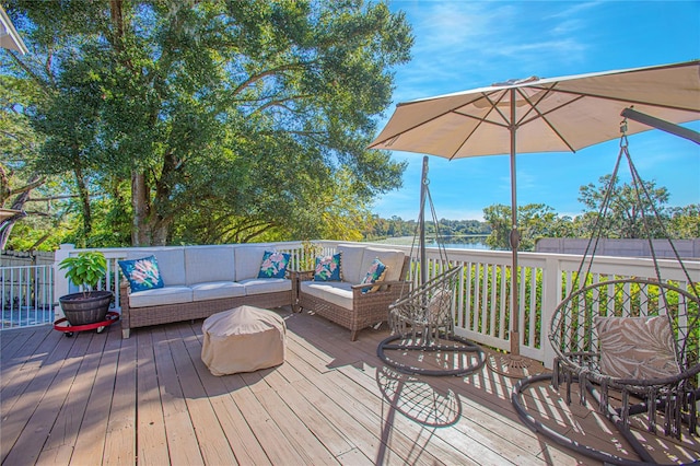 deck with outdoor lounge area and a water view