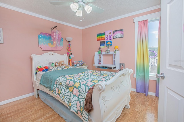 bedroom with ceiling fan, light hardwood / wood-style flooring, a textured ceiling, and ornamental molding