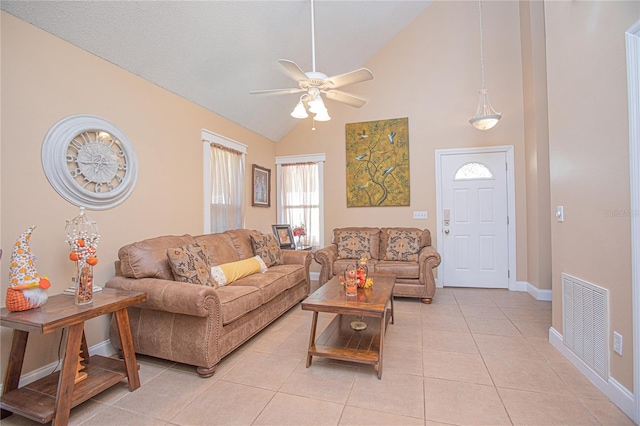 tiled living room with ceiling fan and high vaulted ceiling