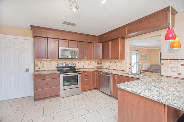 kitchen with sink, appliances with stainless steel finishes, tasteful backsplash, light stone counters, and kitchen peninsula