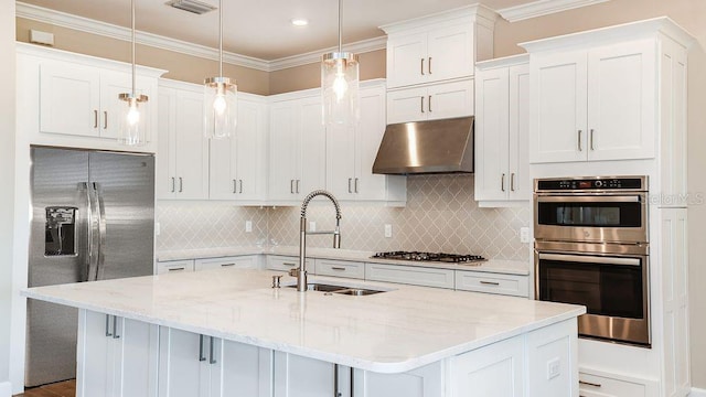 kitchen featuring a center island with sink, hanging light fixtures, sink, appliances with stainless steel finishes, and white cabinetry