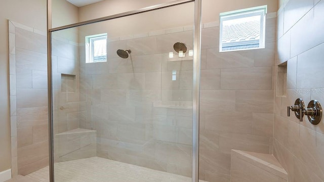 bathroom featuring tiled shower and plenty of natural light