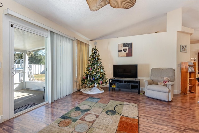 living room featuring a textured ceiling, ceiling fan, wood-type flooring, and lofted ceiling