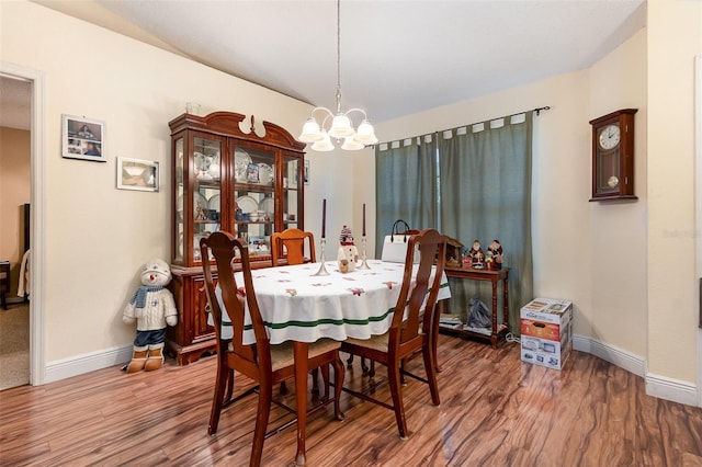 dining room with hardwood / wood-style floors and an inviting chandelier