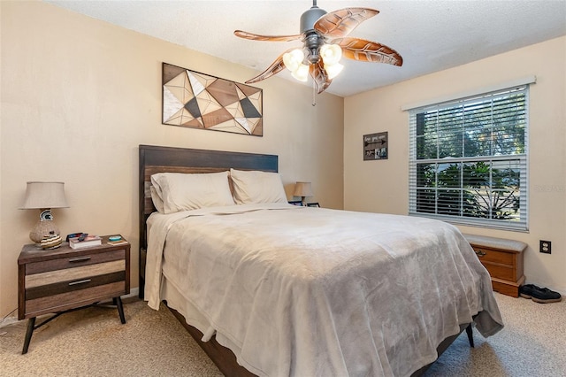 bedroom with ceiling fan, carpet, and a textured ceiling