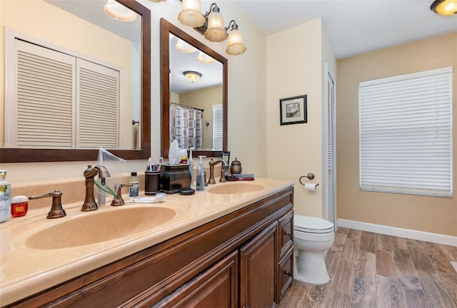 bathroom featuring vanity, wood-type flooring, and toilet