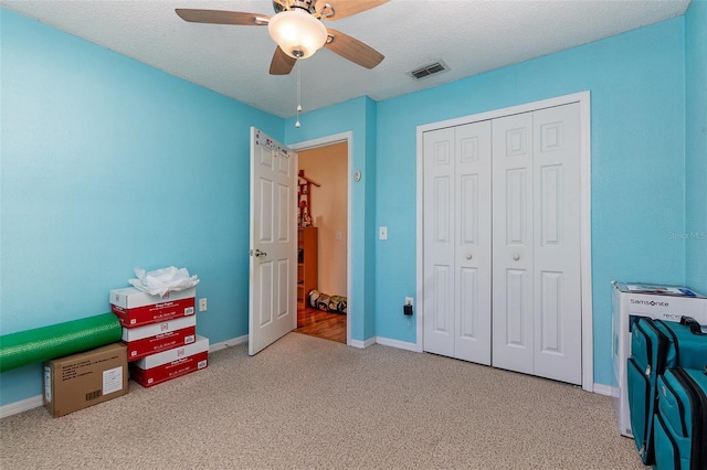 bedroom featuring carpet flooring, a textured ceiling, a closet, and ceiling fan