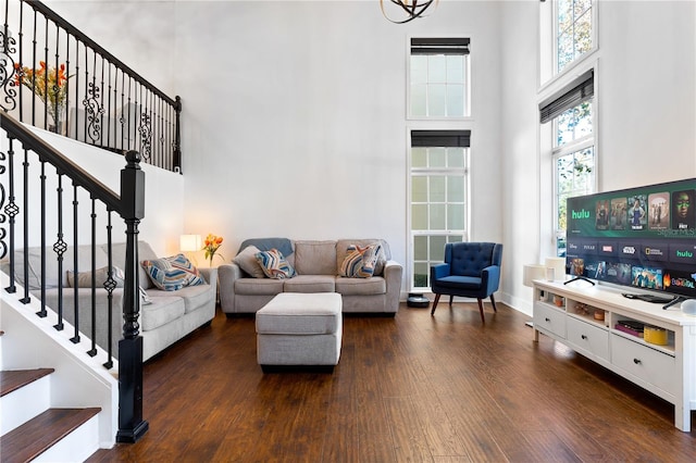 living room with dark hardwood / wood-style flooring and a towering ceiling