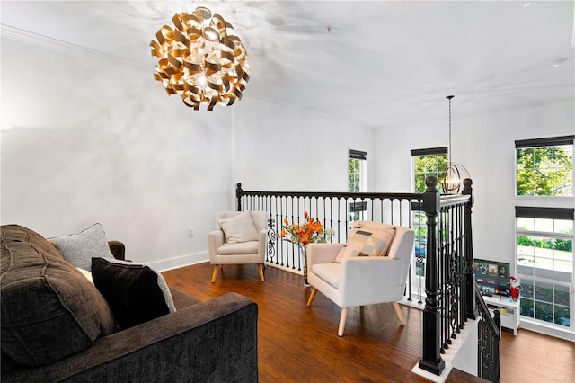 sitting room featuring dark hardwood / wood-style flooring, ornamental molding, and an inviting chandelier