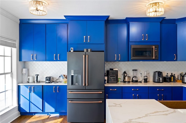 kitchen featuring a notable chandelier, a wealth of natural light, and appliances with stainless steel finishes