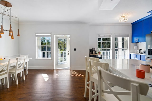 dining room with dark hardwood / wood-style floors, an inviting chandelier, and ornamental molding