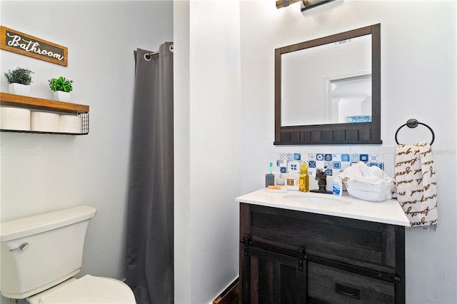 bathroom with backsplash, vanity, and toilet