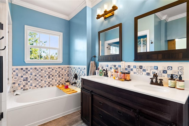 bathroom featuring vanity, backsplash, crown molding, wood-type flooring, and a tub