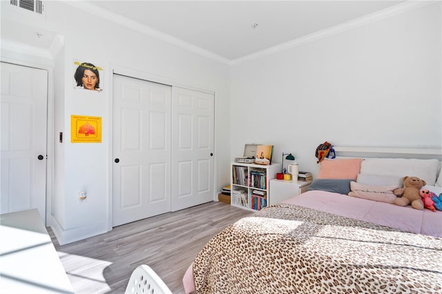 bedroom with light wood-type flooring, a closet, and ornamental molding