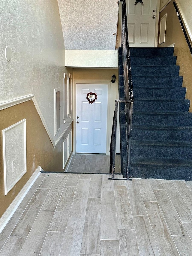 interior space with hardwood / wood-style floors, a textured ceiling, and vaulted ceiling