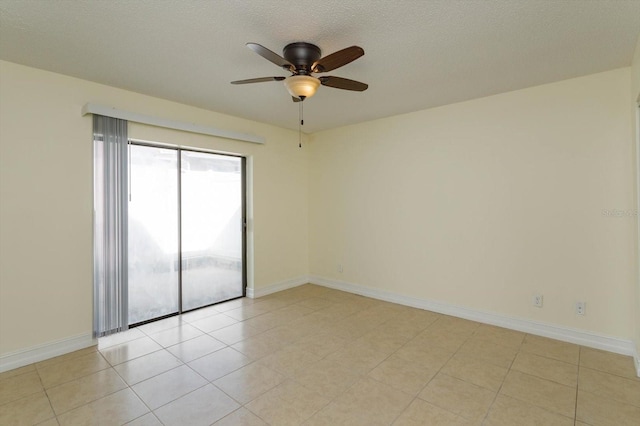 spare room with a textured ceiling, ceiling fan, and light tile patterned flooring