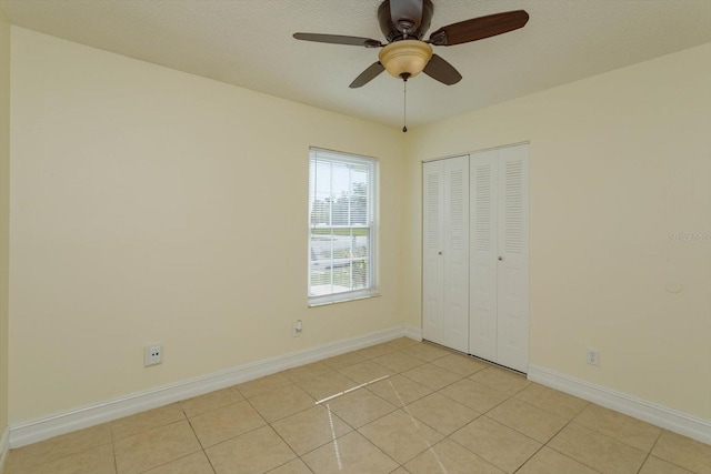 unfurnished bedroom with a closet, ceiling fan, and light tile patterned flooring