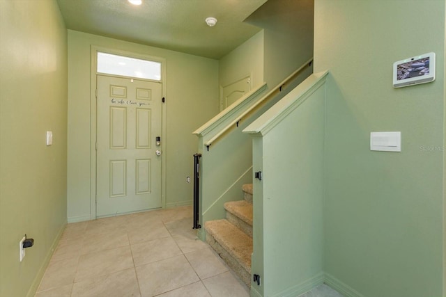 foyer with light tile patterned floors and a textured ceiling