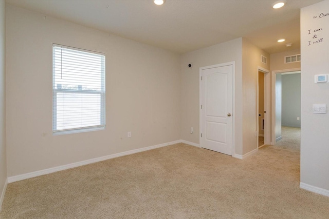 spare room featuring light carpet