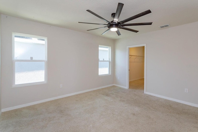 empty room with light colored carpet and ceiling fan