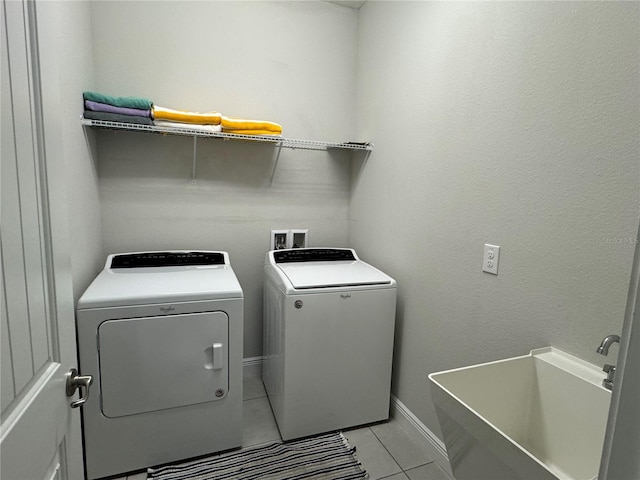 laundry area with washing machine and clothes dryer, sink, and light tile patterned floors